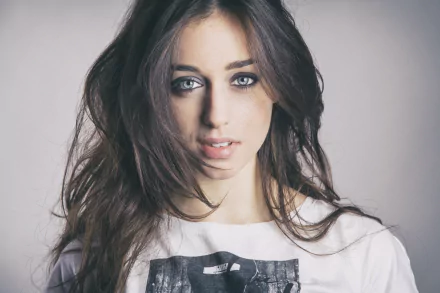 Brunette model with tousled hair and striking blue eyes, close-up face portrait — 5K Ultra HD PC desktop wallpaper/background.