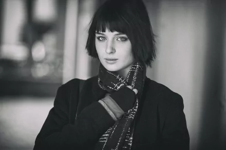 Black-and-white 5K Ultra HD desktop wallpaper of a short-haired woman model wearing a patterned scarf and coat, looking directly at the camera.