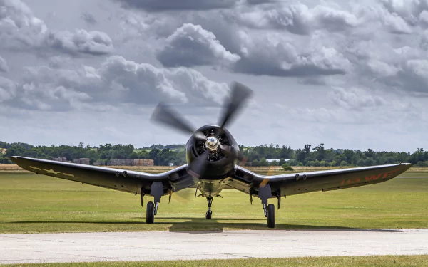 Front view of a Vought F4U Corsair warplane on a runway under a cloudy sky, captured in HD for a military aircraft desktop wallpaper.