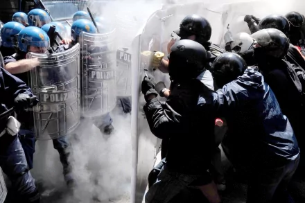 Police in riot gear confront a group amid smoke and chaos. This intense scene captures the clash between military forces and civilians, making for a striking HD desktop wallpaper.