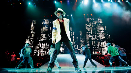 HD PC desktop wallpaper featuring Michael Jackson performing on stage with dancers, vibrant lighting, and a cityscape backdrop, capturing a dynamic music moment.