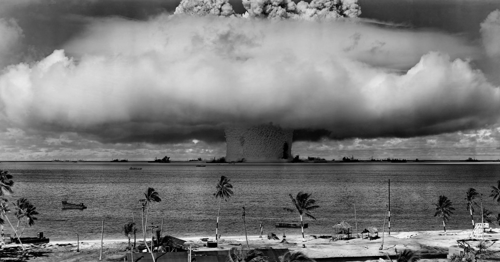 A dramatic black and white image of a nuclear bomb explosion, showcasing military might and the haunting beauty of war, serving as a striking HD desktop wallpaper.