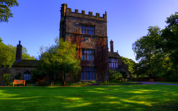 A luxurious mansion surrounded by lush green grass, featuring elegant architecture and a serene garden, showcased in vibrant 4K Ultra HD quality.