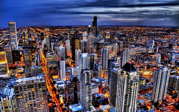 HD desktop wallpaper showcasing Chicago's illuminated city skyline at dusk, featuring vibrant lights and towering buildings in this bustling metropolis.