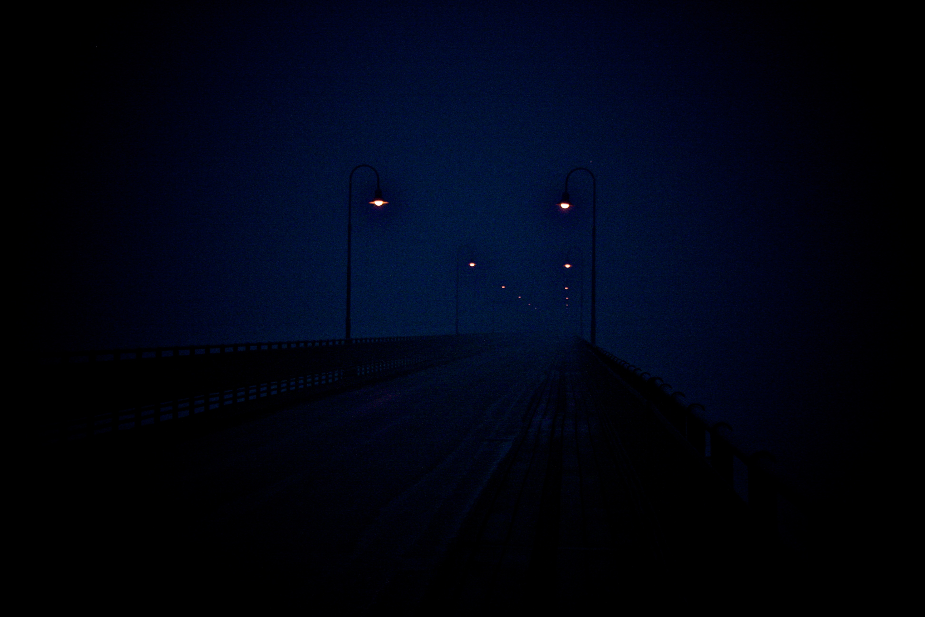 Moonlit bridge over a road at night