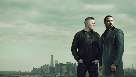 HD desktop wallpaper featuring two main characters from the TV show Power standing against a cloudy sky with a city skyline in the background.