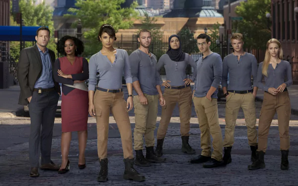 HD desktop wallpaper of the Quantico TV show cast standing together on a city street — an ensemble of agents in uniform, confident poses and urban backdrop.