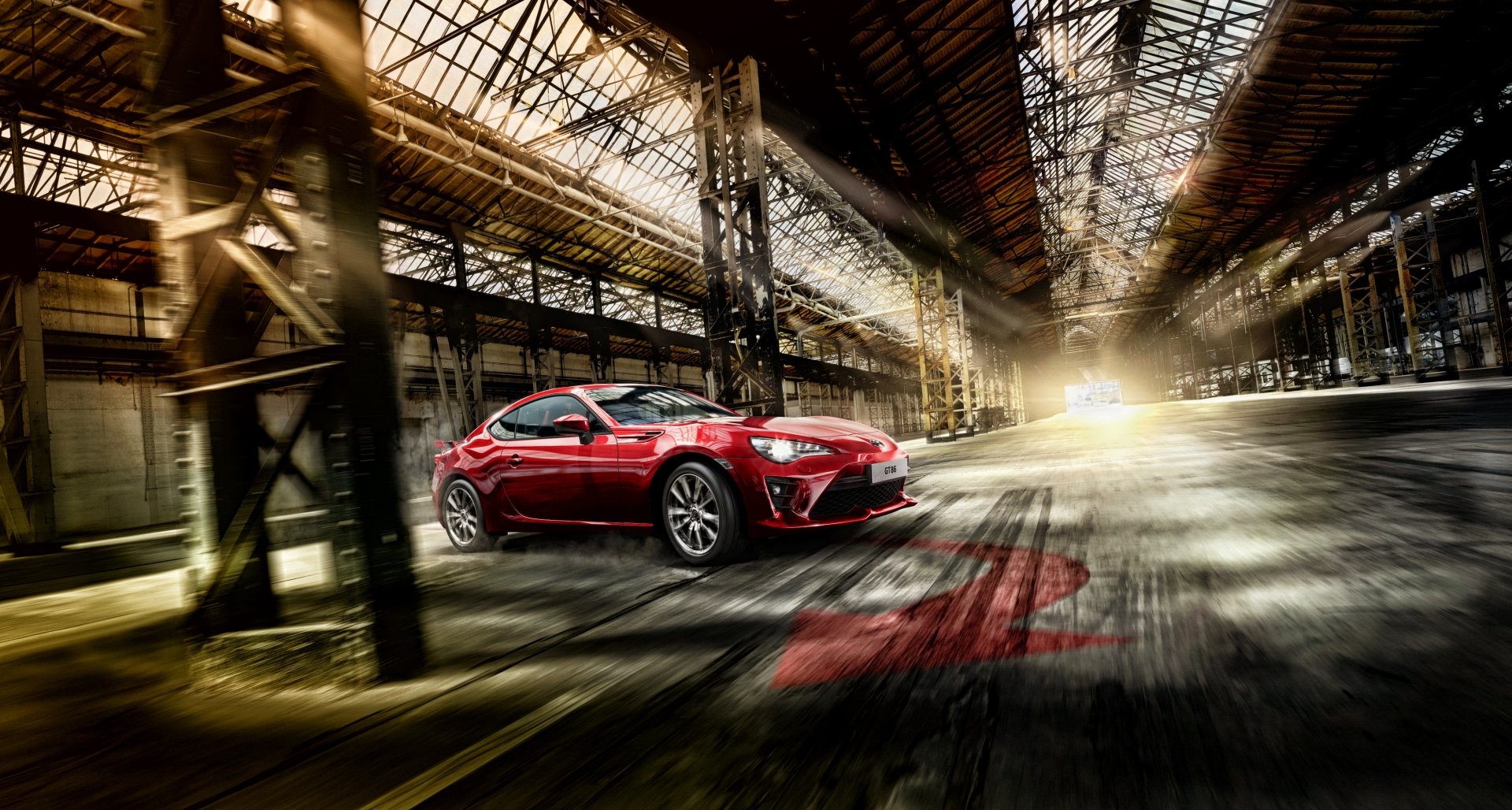 A red Toyota 86 sports car inside an industrial warehouse, showcased as a 4K Ultra HD PC desktop wallpaper and background.