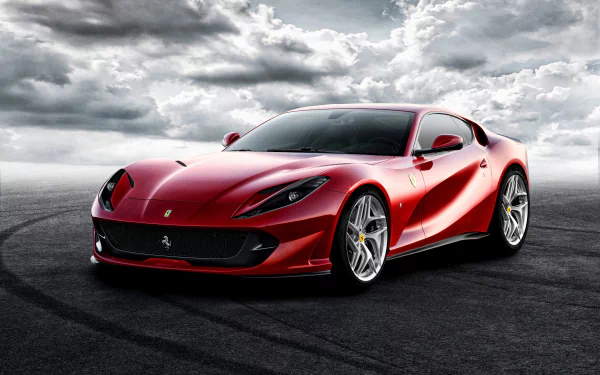 A red Ferrari 812 Superfast grand tourer supercar on a dark asphalt surface under a dramatic cloudy sky, captured in high-definition for a PC desktop wallpaper.