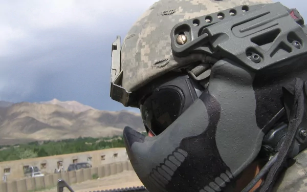 HD desktop wallpaper featuring a close-up of a soldier in tactical gear with a mountainous landscape in the background. Tagged with: military, soldier.