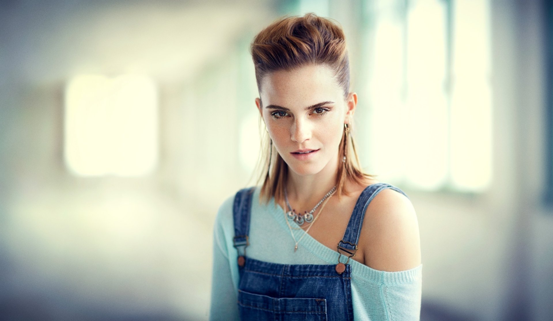 HD desktop wallpaper featuring English actress Emma Watson with brunette hair, brown eyes, wearing a necklace, captured with a soft depth of field background.