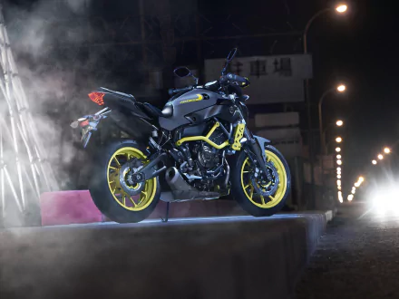 4K Ultra HD PC desktop wallpaper of a Yamaha MT-07 motorcycle: dark Yamaha vehicle with neon yellow rims and accents, posed on a concrete ledge at night with streetlights and smoke.