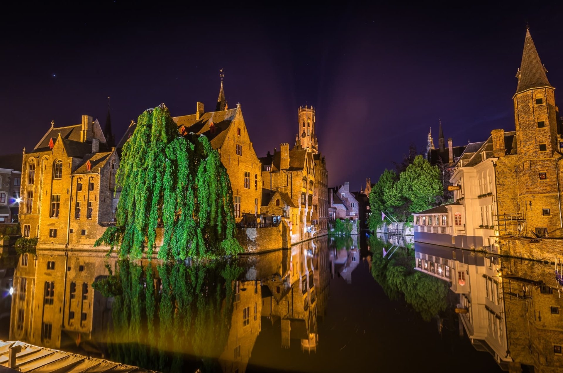 Night view of Bruges town in Belgium with historic houses and their reflections in a tranquil canal, captured in HD for a vivid desktop wallpaper background.