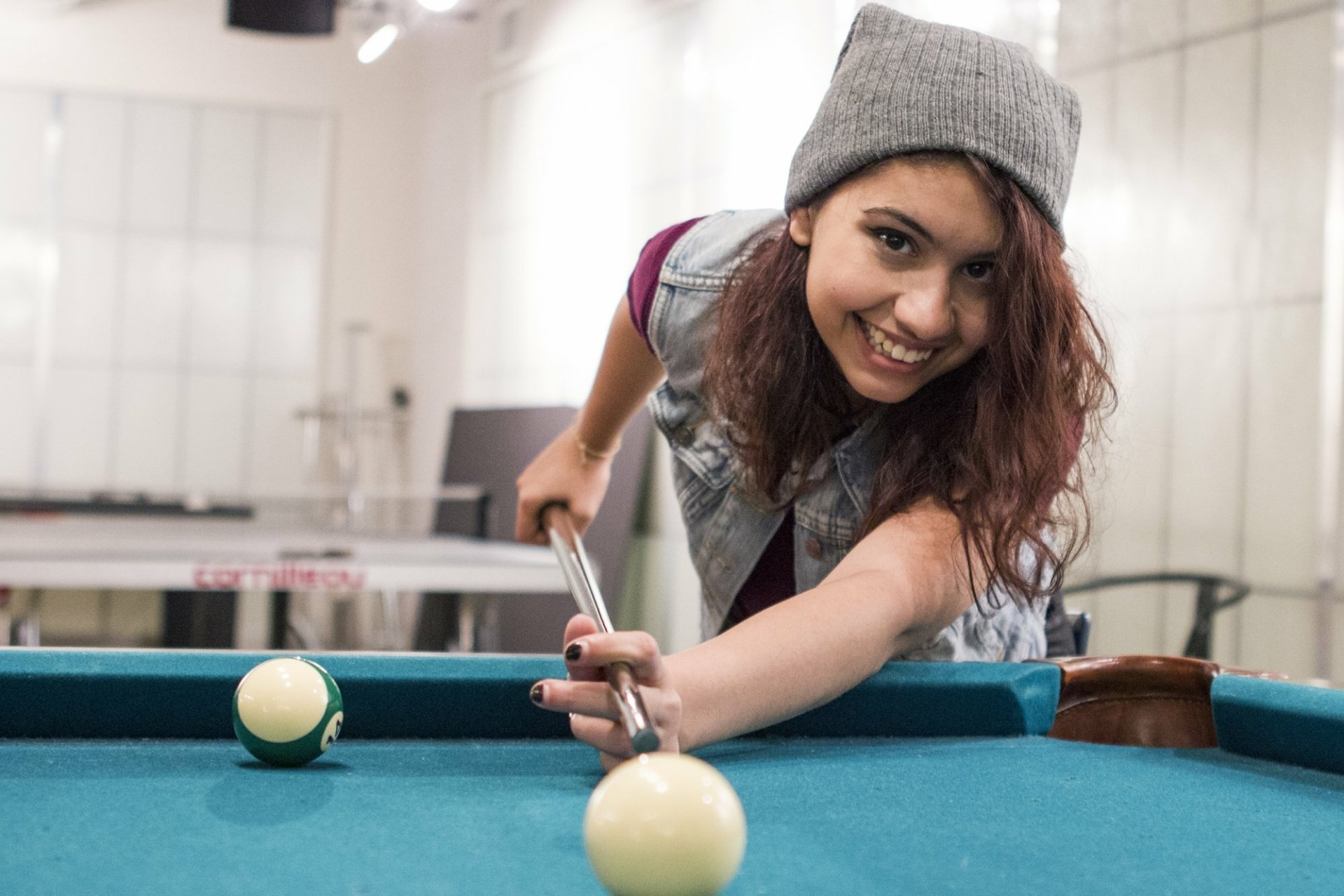 HD desktop wallpaper featuring a smiling person playing pool, suitable as a cheerful background.