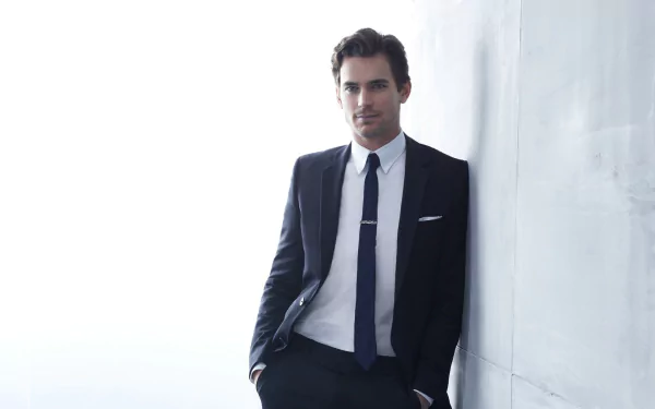 HD desktop wallpaper featuring Matt Bomer in a sharp suit leaning against a white wall.