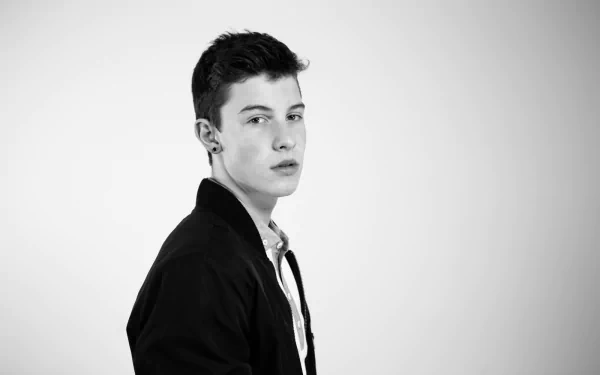 Black and white HD desktop wallpaper featuring a portrait of Shawn Mendes in a black jacket, white shirt, looking to the side.
