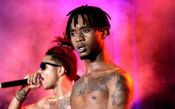 Rae Sremmurd performing on stage, vibrant pink and purple background, HD desktop wallpaper.