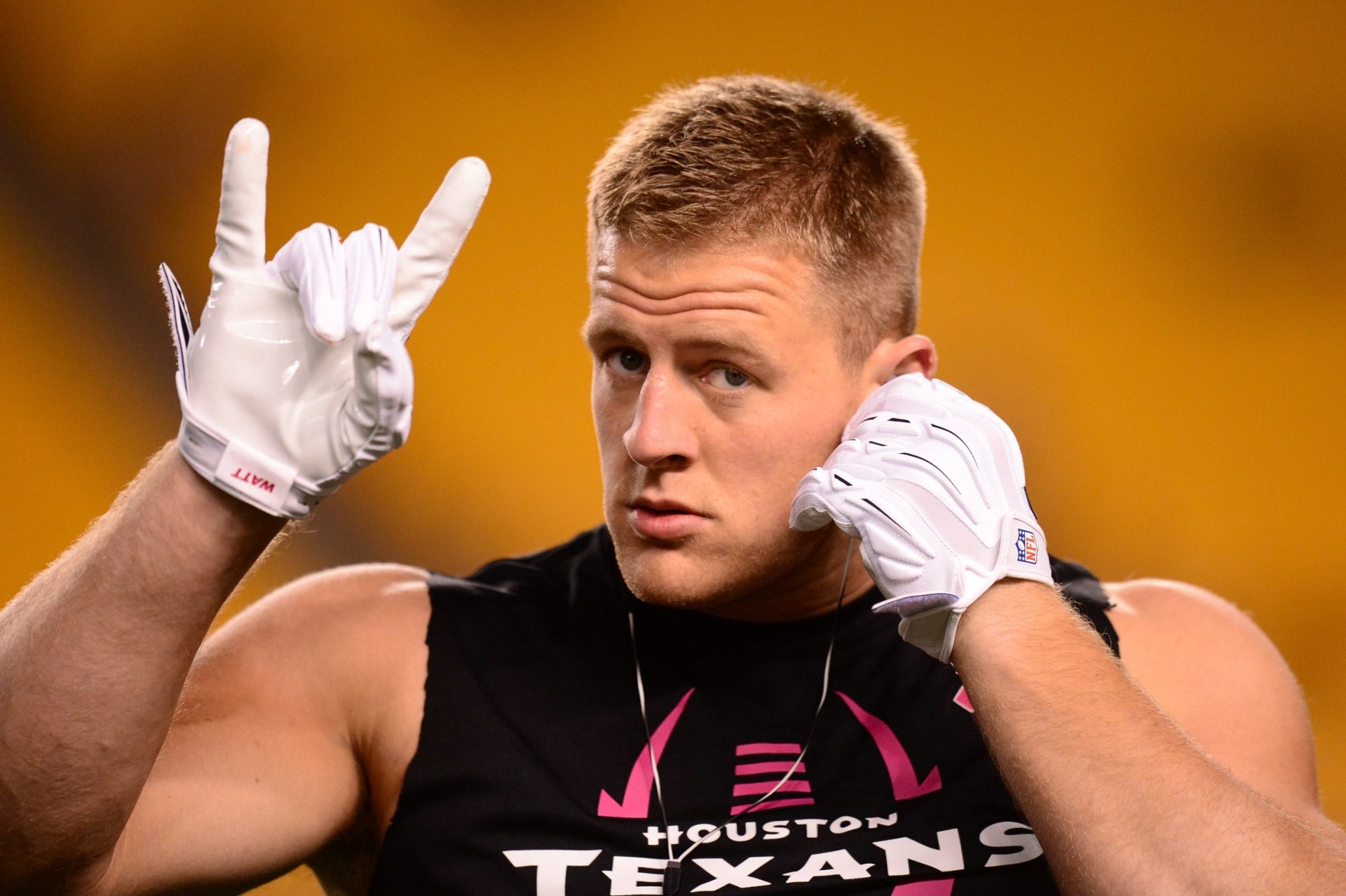 J.J. Watt of the Houston Texans poses confidently, making a gesture as he prepares for a game, showcasing his dedication to football in this HD desktop wallpaper background.