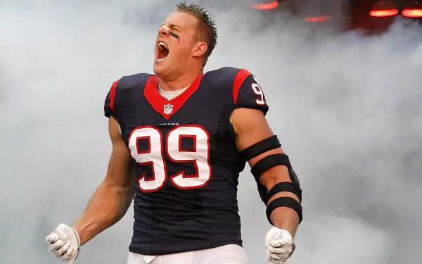 HD desktop wallpaper featuring Houston Texans' J.J. Watt in full gear, passionately celebrating on the field with smoke and lights in the background.