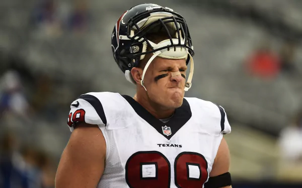 Houston Texans linebacker J.J. Watt in uniform, helmet raised, captured in an intense moment on the field, featured in an HD PC desktop wallpaper.