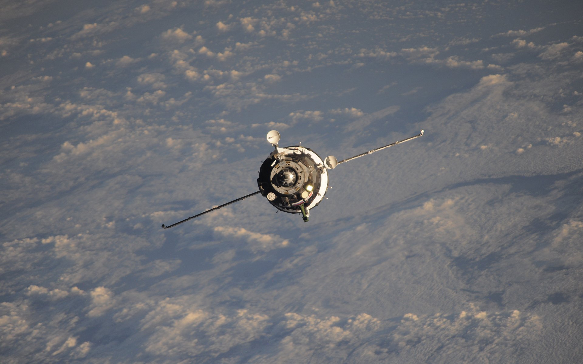 Sci‑fi satellite drifting above cloud-covered Earth — 2K Quad HD PC desktop wallpaper and background.