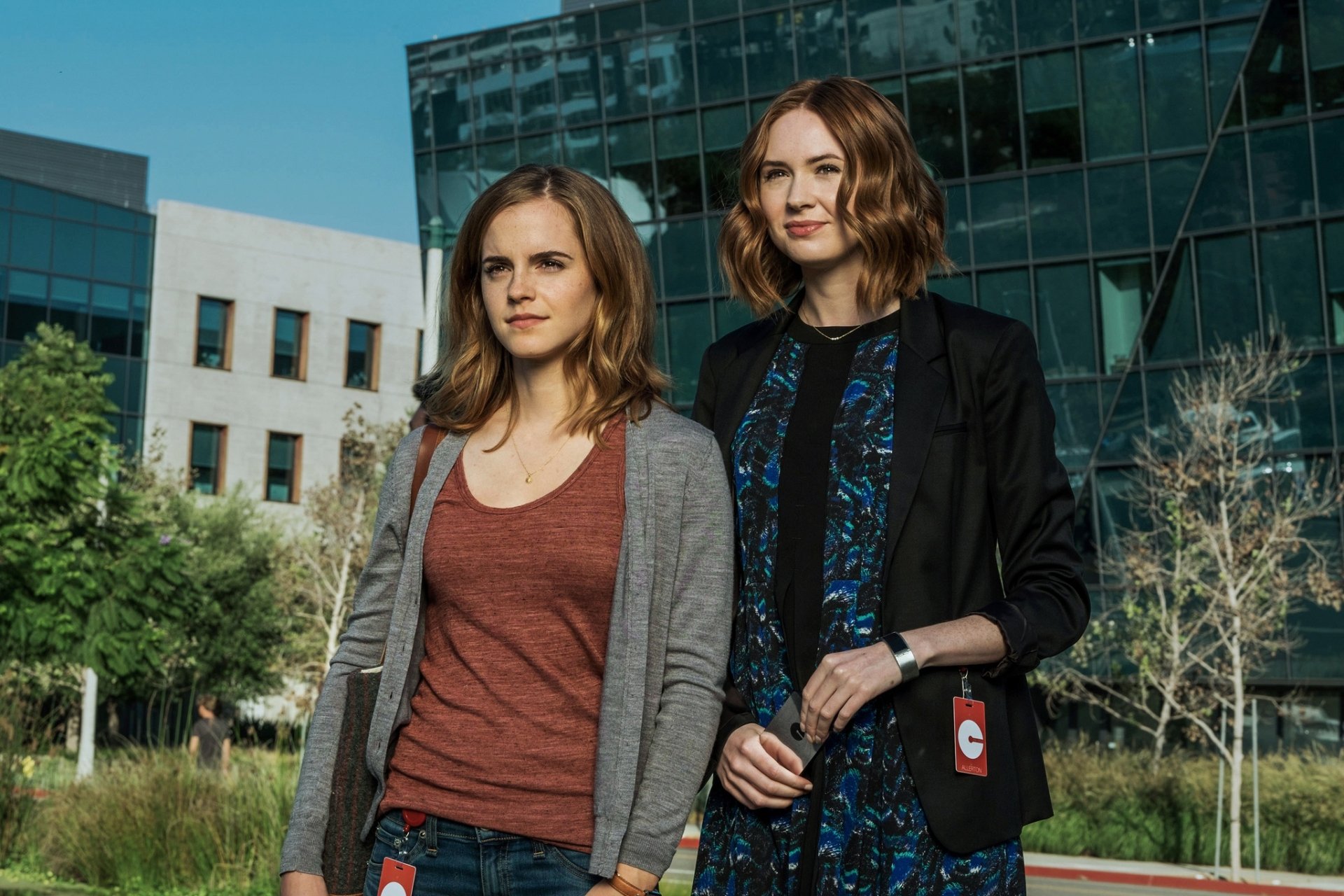HD desktop wallpaper featuring Karen Gillan and Emma Watson from the movie The Circle, standing outdoors in front of modern glass buildings.