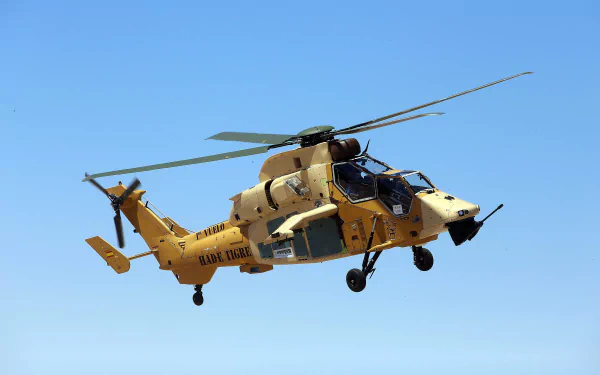 4K Ultra HD image of a Eurocopter Tiger attack helicopter in flight against a clear blue sky, highlighting its military design and advanced aircraft features.
