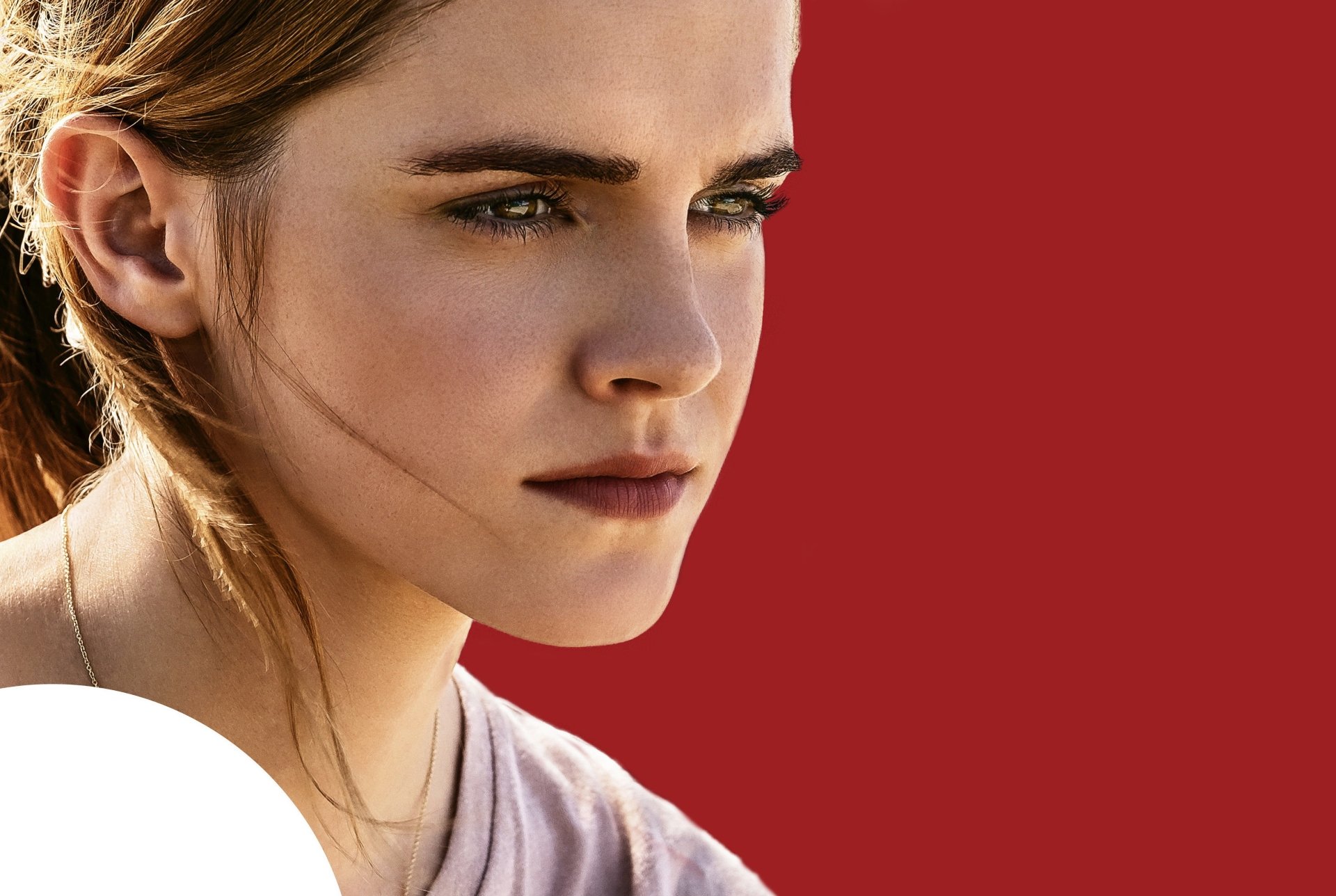 Close-up of Emma Watson's face from the movie The Circle, featured as an HD PC desktop wallpaper with a solid red background.