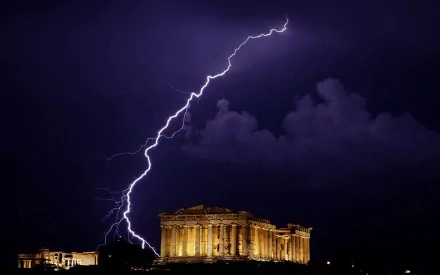 The Parthenon in Greece illuminated by dramatic lightning against a dark sky, creating a striking photography backdrop for your HD desktop wallpaper.