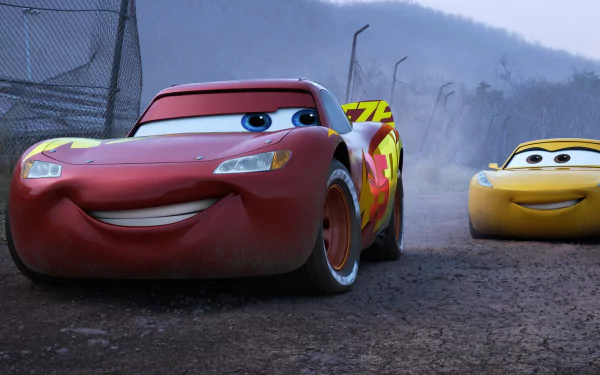 HD desktop wallpaper featuring Lightning McQueen and another car character from the movie Cars 3, set against a rugged outdoor backdrop with a misty, mountainous landscape.