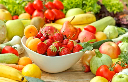 A vibrant 4K Ultra HD still life of assorted fruits and vegetables arranged on a table, showcasing fresh strawberries, apples, tomatoes, and leafy greens in a bright setting.