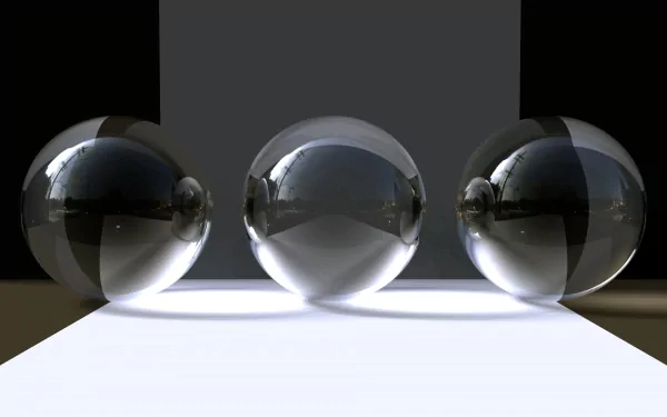 HD desktop wallpaper featuring three reflective glass orbs on a minimalist surface with cool lighting and shadows, showcasing sleek, modern photography.