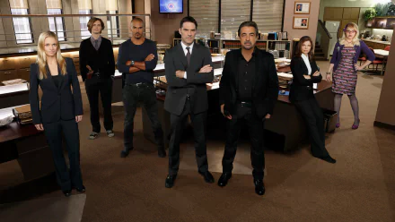 HD PC desktop wallpaper featuring the main cast of the TV show Criminal Minds standing confidently in their office setting.