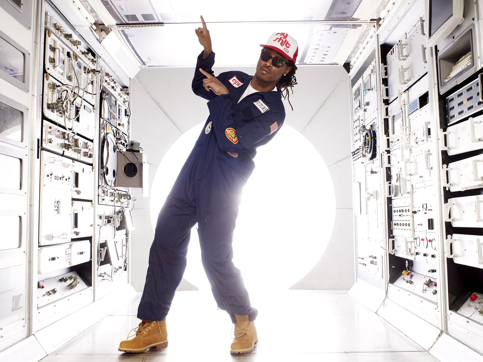HD wallpaper featuring a rapper in a space-themed outfit posing inside a spaceship corridor, designed for futuristic desktop backgrounds.