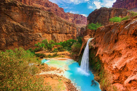 HD PC desktop wallpaper showing Havasu Falls cascading into a turquoise pool in a red-rock canyon, surrounded by lush vegetation and a vivid blue sky.