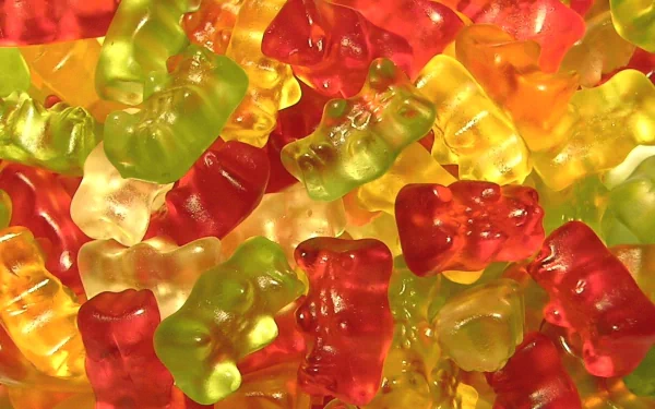 A vibrant HD wallpaper featuring a colorful array of gummy bears in various shapes and flavors, showcasing their playful appeal and tempting sweetness.