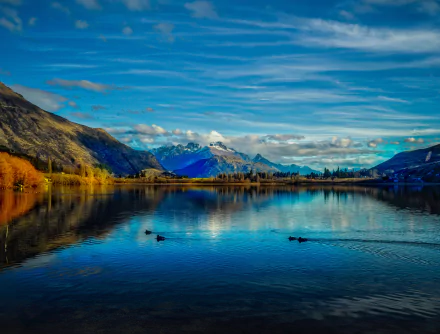 Stunning 8K Ultra HD landscape of Lake Hayes in New Zealand, featuring serene waters, surrounding mountains, and a vibrant sky reflecting on the lake’s surface.