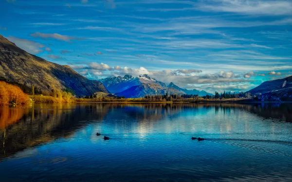 Stunning 8K Ultra HD landscape of Lake Hayes in New Zealand, featuring serene waters, surrounding mountains, and a vibrant sky reflecting on the lake’s surface.