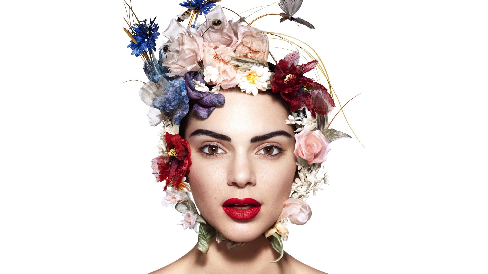 Close-up of American model Kendall Jenner with brown eyes and bold lipstick, adorned with a colorful flower wreath, captured in 4K Ultra HD for a desktop wallpaper.