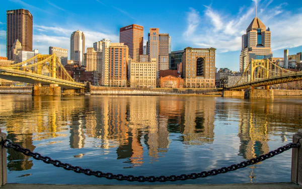HD PC desktop wallpaper of Pittsburgh, USA: bridges and skyscrapers reflected on the river, city skyline showcasing buildings and man-made architecture.
