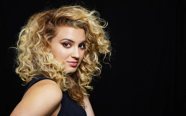 HD desktop wallpaper featuring a portrait of a woman with curly blonde hair against a black background.