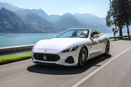 White Maserati GranCabrio supercar grand tourer driving along a scenic lakeside road, captured in stunning 4K Ultra HD for PC desktop wallpaper.