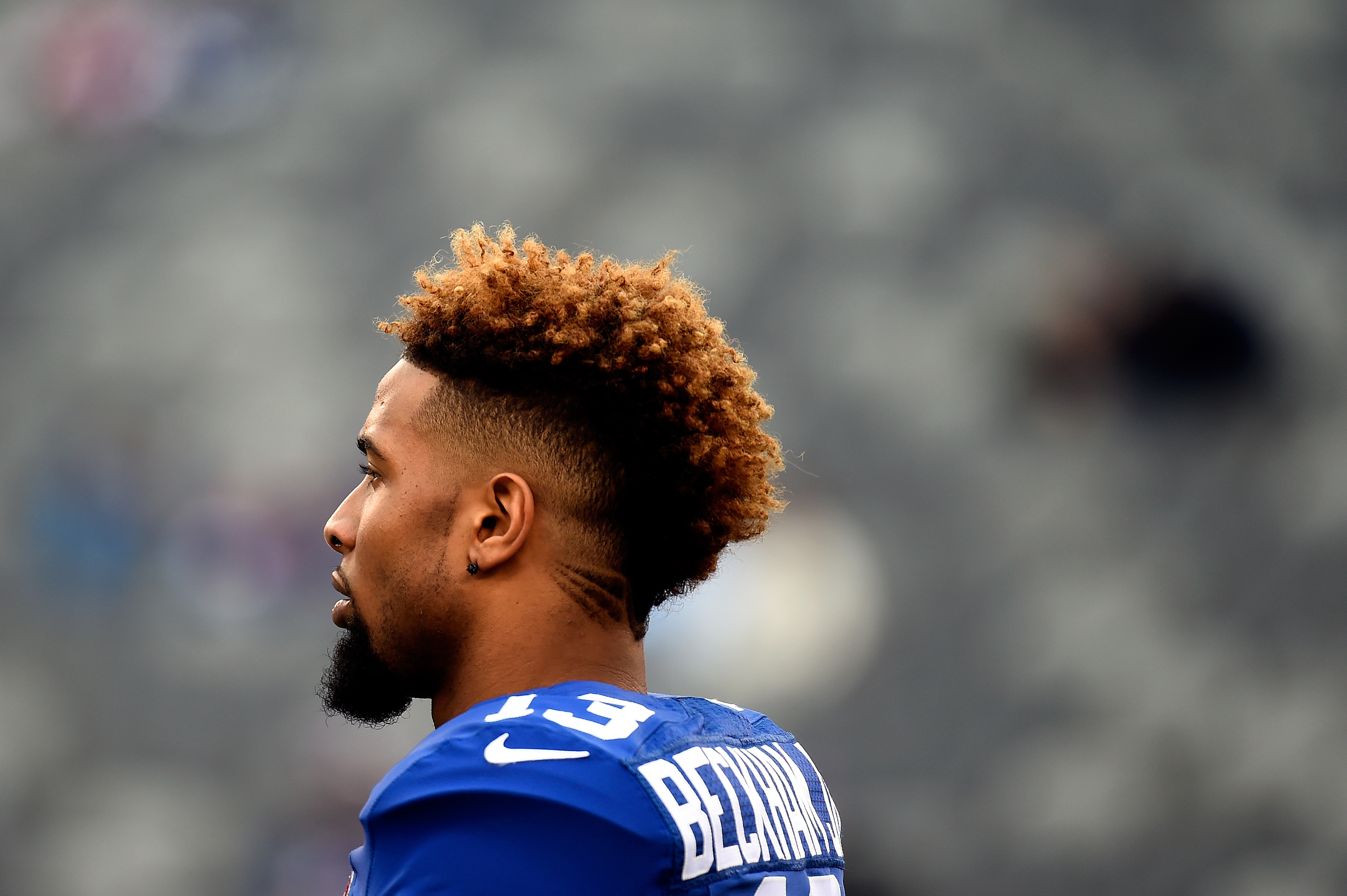 HD desktop wallpaper of a New York Giants player in blue jersey number 13, with the focus on his profile against a blurred stadium background.