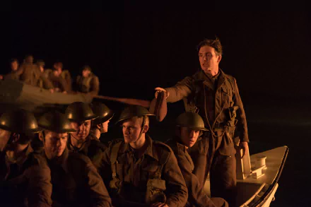 HD desktop wallpaper of the movie Dunkirk featuring Cillian Murphy. He stands among soldiers in a boat, creating a tense and dramatic atmosphere.