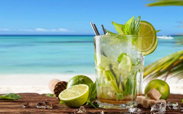 4K Ultra HD image of a refreshing tropical mojito cocktail with lemon, lime, mint, and crushed ice on a wooden surface by a sunny beach.