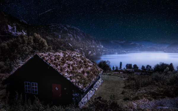 A grassy-roofed house by a Norwegian lake at night, under a star-filled sky, captured in HD for a serene desktop wallpaper background.