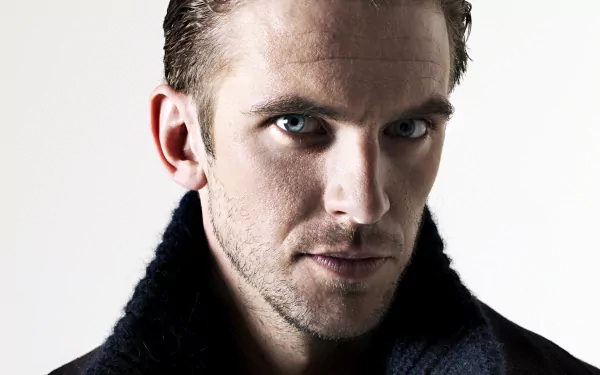 A striking HD desktop wallpaper featuring Dan Stevens, showcasing his intense gaze and sharp features, enhanced by a simple background.