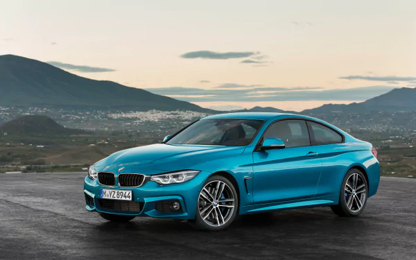Teal BMW 4 Series coupe on asphalt with mountains at dusk — car/vehicle 4K Ultra HD PC desktop wallpaper and background.