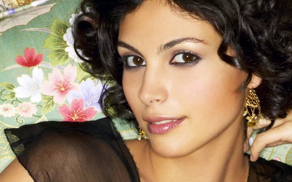 HD PC desktop wallpaper featuring a close-up portrait of celebrity Morena Baccarin with soft makeup and curly dark hair against a floral background.
