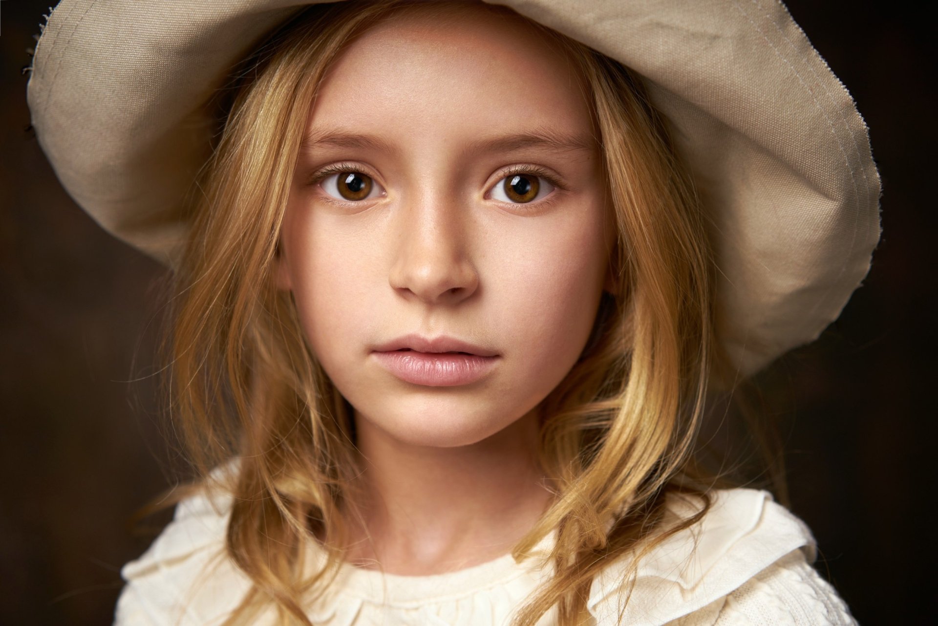 Close-up photography of a child with brown eyes wearing a soft, wide-brimmed hat, captured in high definition for a PC desktop wallpaper background.